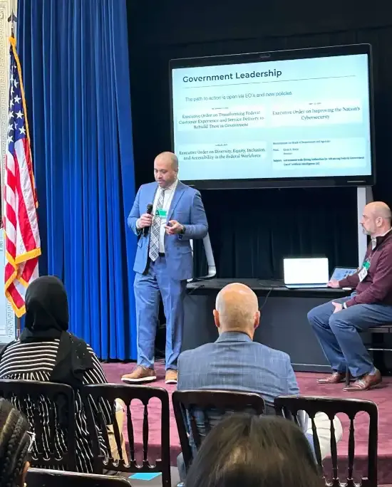 Neil Chaudhuri presenting examples of government leadership on a slide to the audience.